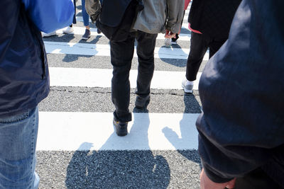 Low section of people walking on city street