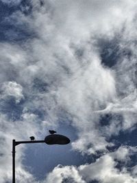 Low angle view of street light against cloudy sky