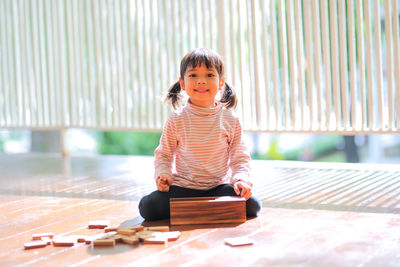 Portrait of cute girl sitting on floor