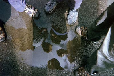 Low section of people standing in puddle