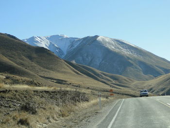 Road amidst mountains against clear sky