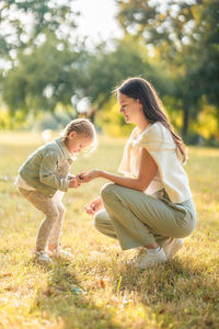 Side view of young woman sitting on grass