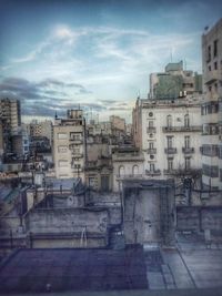 Buildings against cloudy sky