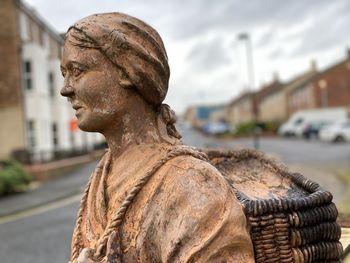 Close-up of statue against city