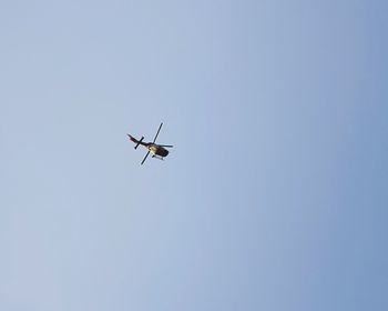 Low angle view of helicopter against clear sky