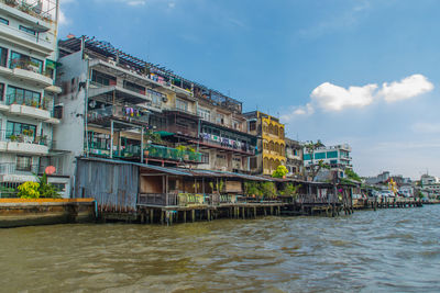 Buildings by sea against sky in city