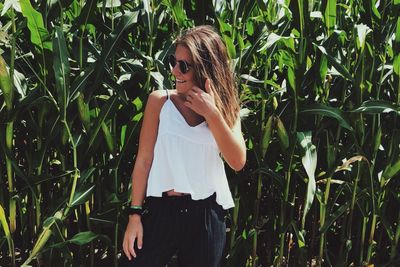 Woman standing by plants on field