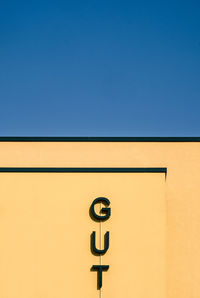 Low angle view of sign against clear sky