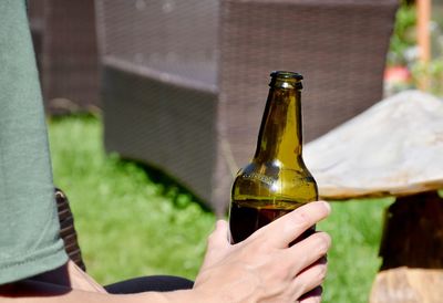 Cropped image of person holding beer bottle