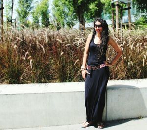 Portrait of woman in sunglasses standing by plants