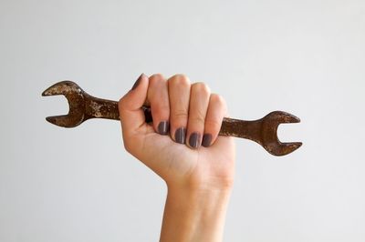 Close-up of person holding hands against white background