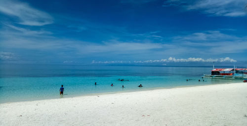 Scenic view of beach against blue sky