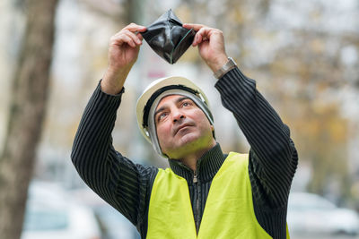 Engineer in reflective clothing looking at wallet