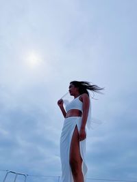 Low angle view of woman standing against sky