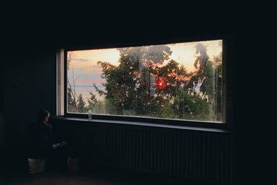 Boy looking through window