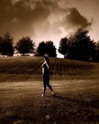 Silhouette of woman walking on field