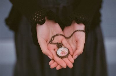 High angle view of woman holding watch on hand