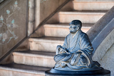 Statue of angel against wall and building