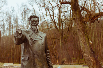 Man with arms raised against trees