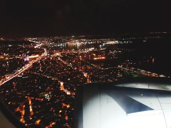 Illuminated cityscape against sky at night