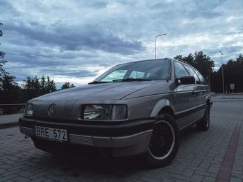 Vintage car parked on road against cloudy sky