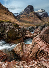 River coe flowing through glen coe in winter with the group of mountains known as the three sisters