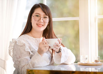 Portrait of smiling woman holding coffee cup
