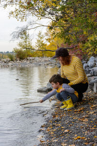 Mother and son enjoying time together by a river in autumn