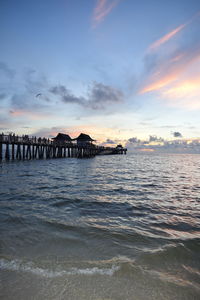 Pier over sea against sky during sunset