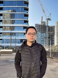 Portrait of man standing against buildings