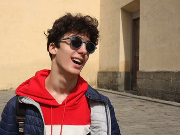 Portrait of teenage boy wearing sunglasses standing outdoors