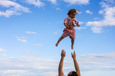 Low angle view of man throwing a girl 