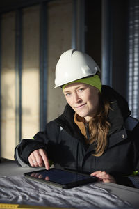 Female engineer checking plans on digital tablet