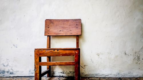 Empty bench on table against wall