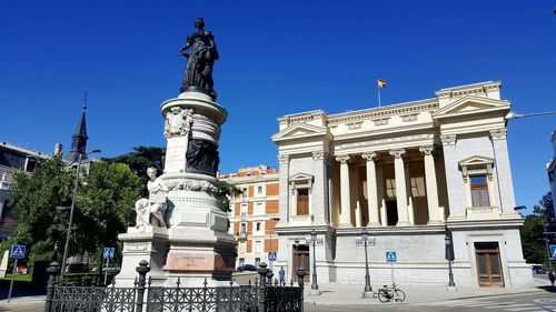 Low angle view of statue against blue sky