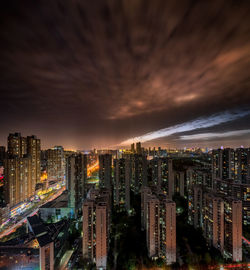 High angle view of illuminated buildings against sky at night