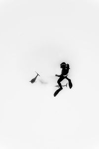 Low angle view of man paragliding over white background