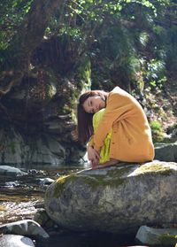 Woman sitting on rock