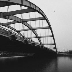 Low angle view of bridge over river against sky