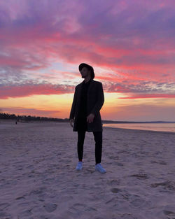 Full length of man standing on beach during sunset