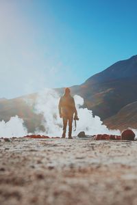 Smoke emitting by silhouette man standing at atacama desert against clear blue sky