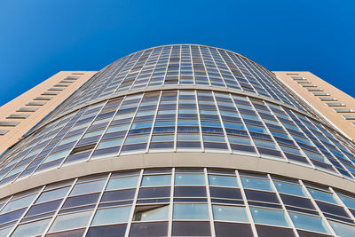 Low angle view of modern building against clear blue sky