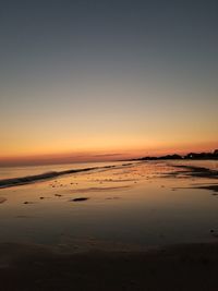 Scenic view of beach against clear sky during sunset