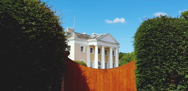 Low angle view of trees and building against sky