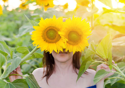 Close-up of woman holding sunflower