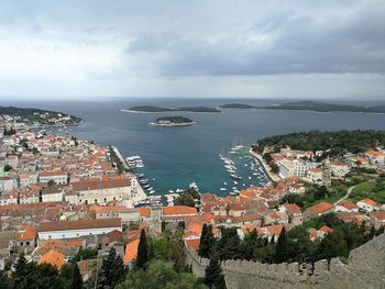 High angle view of townscape by sea against sky