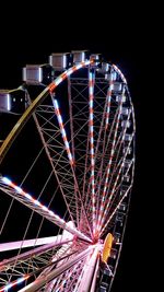 Low angle view of illuminated ferris wheel against sky at night