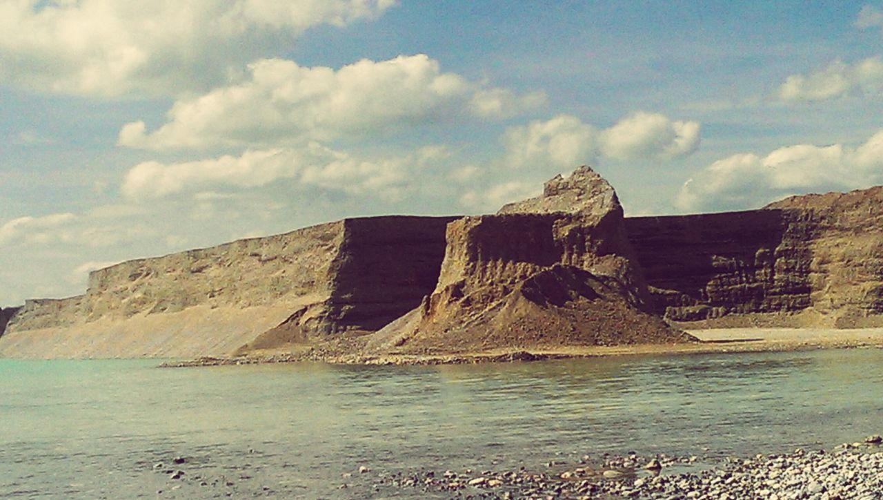 sky, built structure, architecture, cloud - sky, damaged, abandoned, cloud, obsolete, building exterior, rock - object, old, run-down, deterioration, sea, rock formation, tranquility, beach, day, old ruin, nature