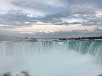 Scenic view of waterfall against sky