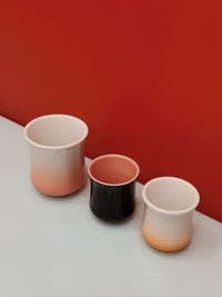 Close-up of coffee cup on table against yellow background